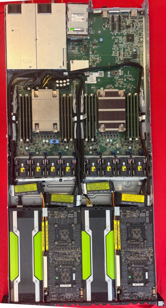 Dell PowerEdge C4130 opened from above: two CPU heatsinks flanked by memory slots, with four NVIDIA Tesla K80 cards along the front of the chassis