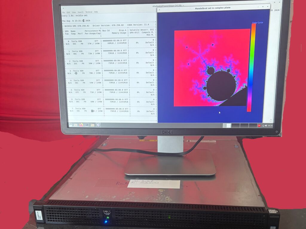 The C4130 rack unit running on a bench under a monitor and keyboard, the screen showing nvidia-smi listing eight Tesla K80 GPUs beside a Mandelbrot set render